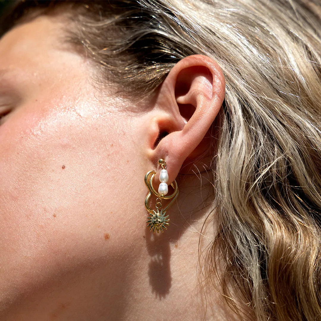 Gold coloured hoop earrings with a sun charm